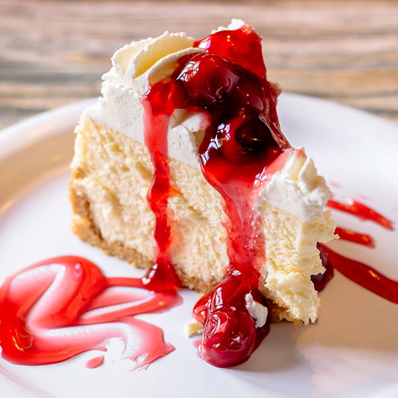 A slice of cheesecake topped with cherry sauce, served at a restaurant near Amnicon Falls.