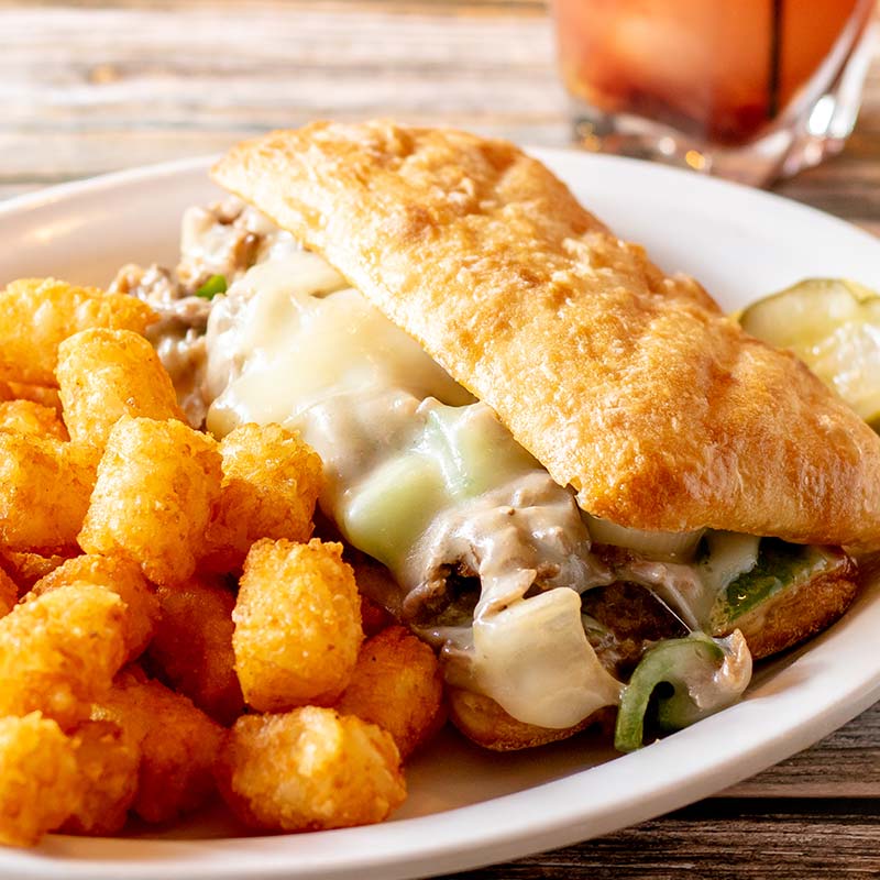 Toasted sandwich with melted cheese, beef, peppers, and tater tots—classic Rapids Riverside taste.