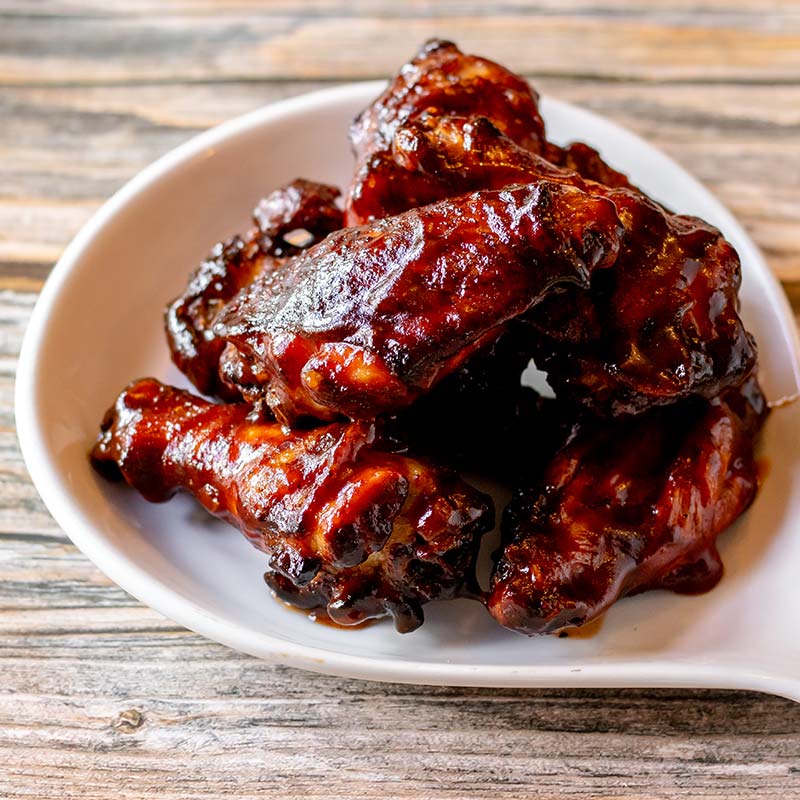 Barbecue chicken wings stacked on a white plate at a restaurant near Amnicon Falls.