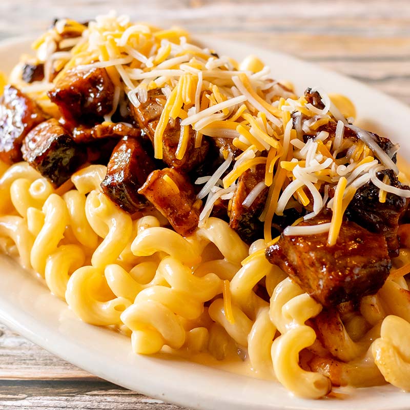 Curly macaroni with cheese, topped with barbecue meat—a Rapids Riverside Friday Fish Fry classic.