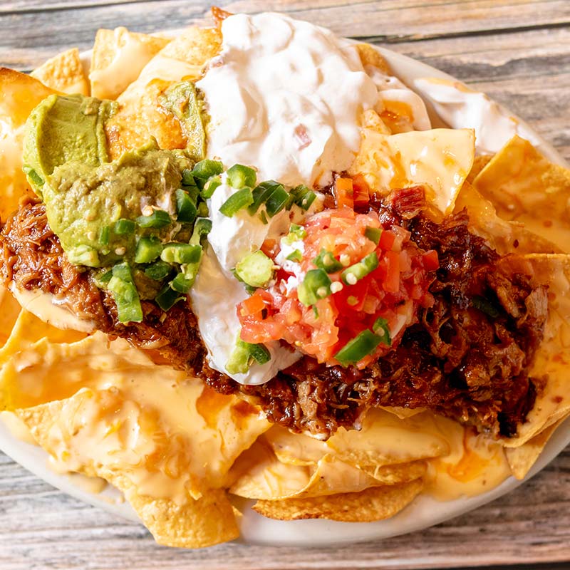 Plate of nachos topped with cheese, guacamole, and pico at a restaurant near Amnicon Falls.