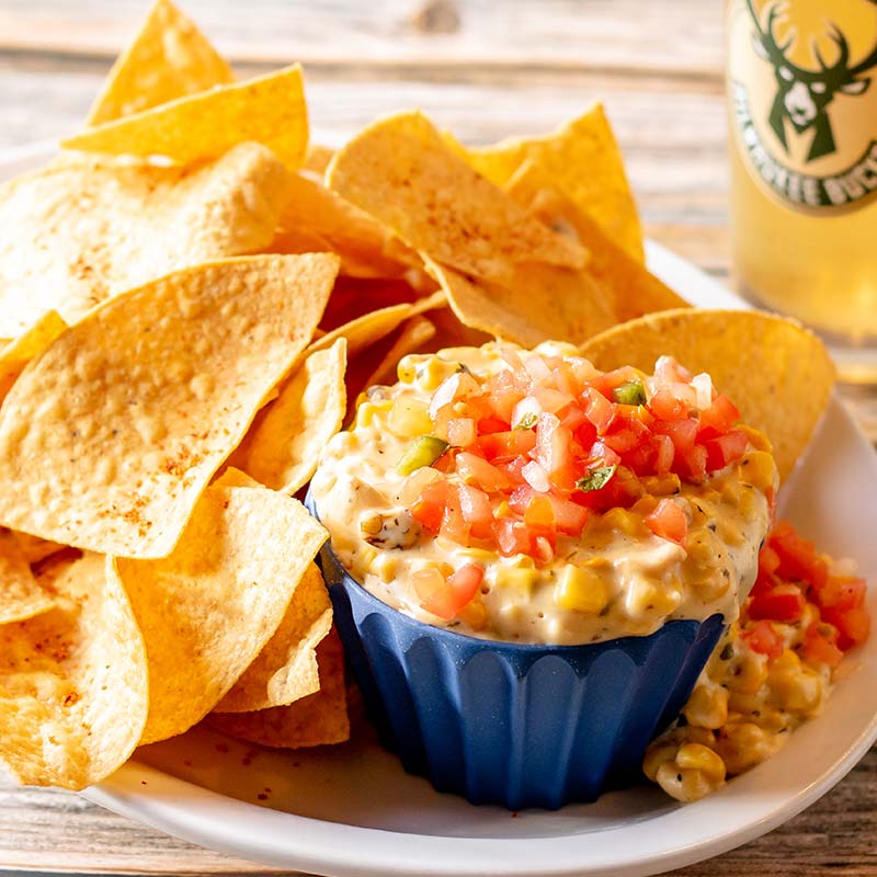 Savor tortilla chips and creamy dip at a restaurant near Amnicon Falls—topped with fresh veggies.